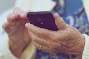 Elderly person's hands holding cellphone